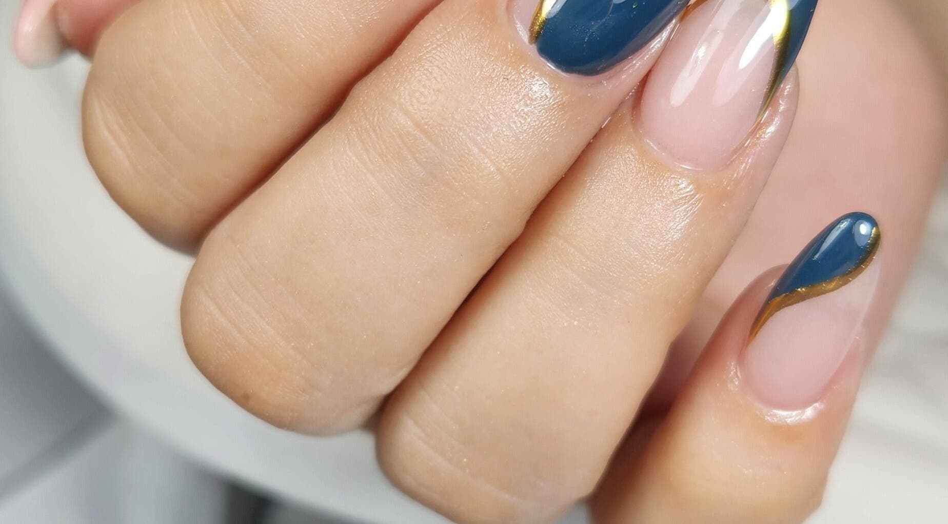 Diseño de uñas azul y dorado en Eliz Nails Studio, Willemstad, CW. Manicura elegante y profesional.