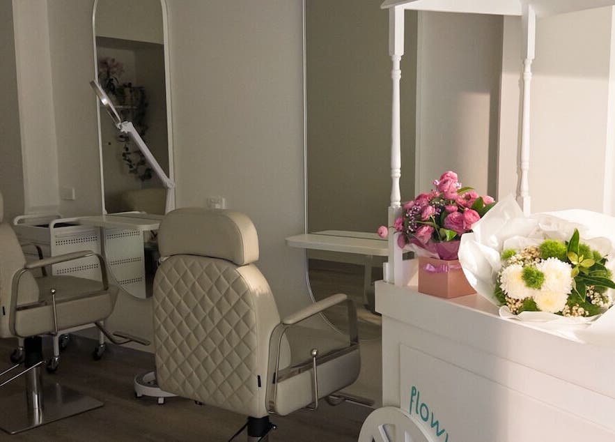 Flowwy brows & lashes salon in Melbourne, Victoria, AU featuring elegant chairs and fresh floral arrangements.