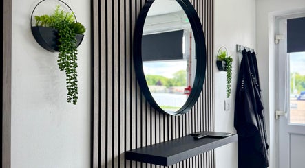 Modern mirror and plants at Hairfinity By Kelly, Wyton, England, GB creating a stylish and inviting ambiance.
