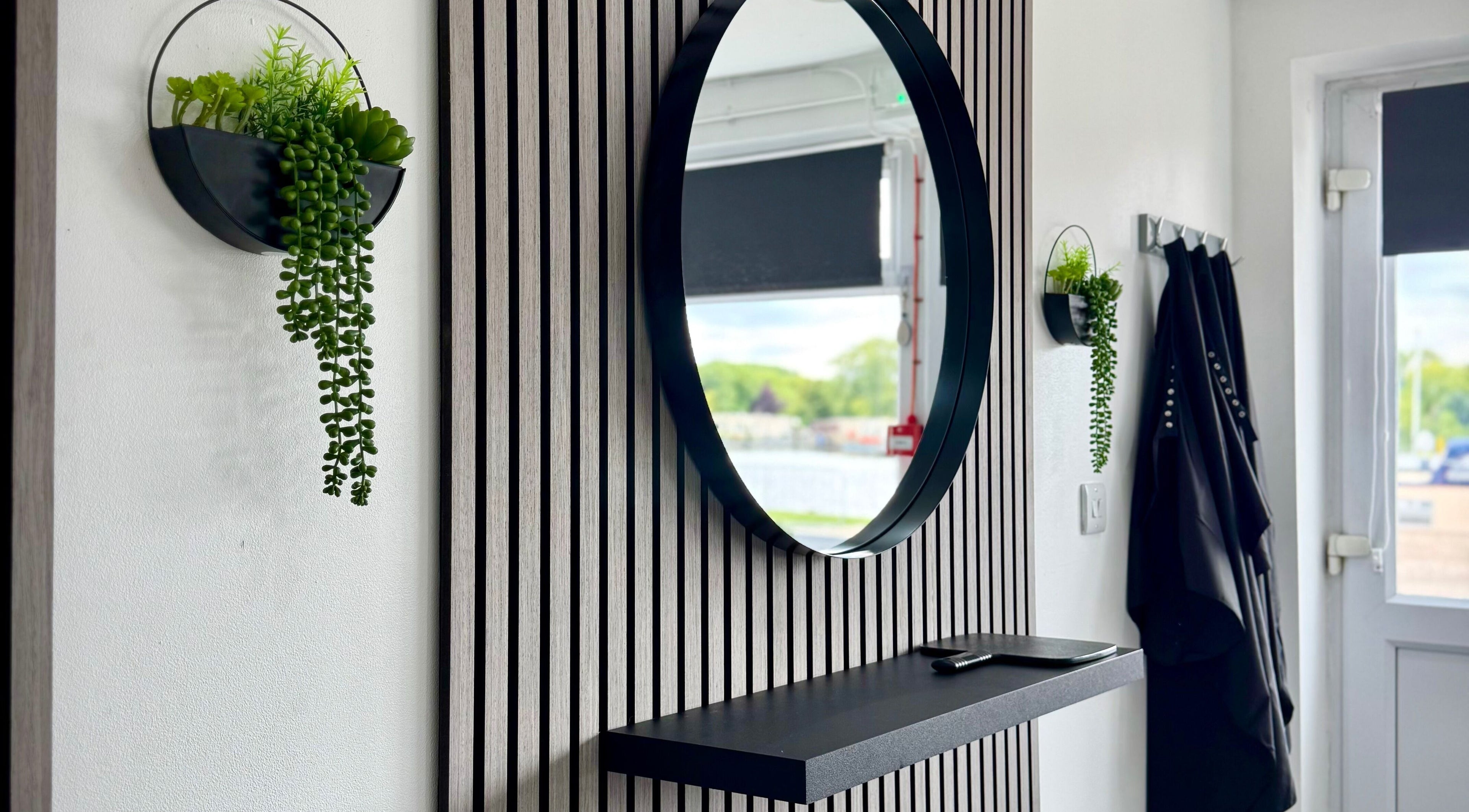 Modern mirror and plants at Hairfinity By Kelly, Wyton, England, GB creating a stylish and inviting ambiance.