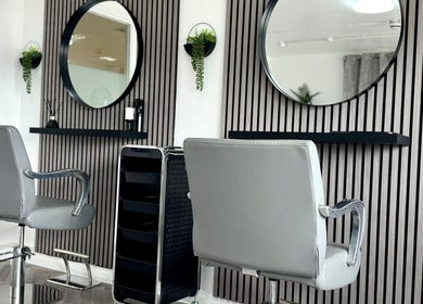 Modern salon interior at Hairfinity By Kelly, Wyton, England, GB with stylish chairs and mirrors.
