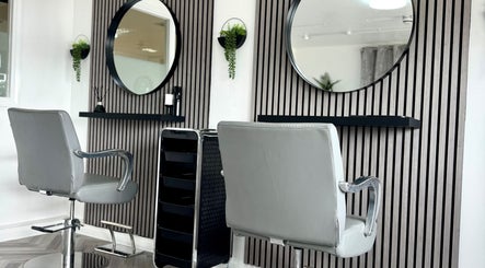 Modern salon interior at Hairfinity By Kelly, Wyton, England, GB with stylish chairs and mirrors.