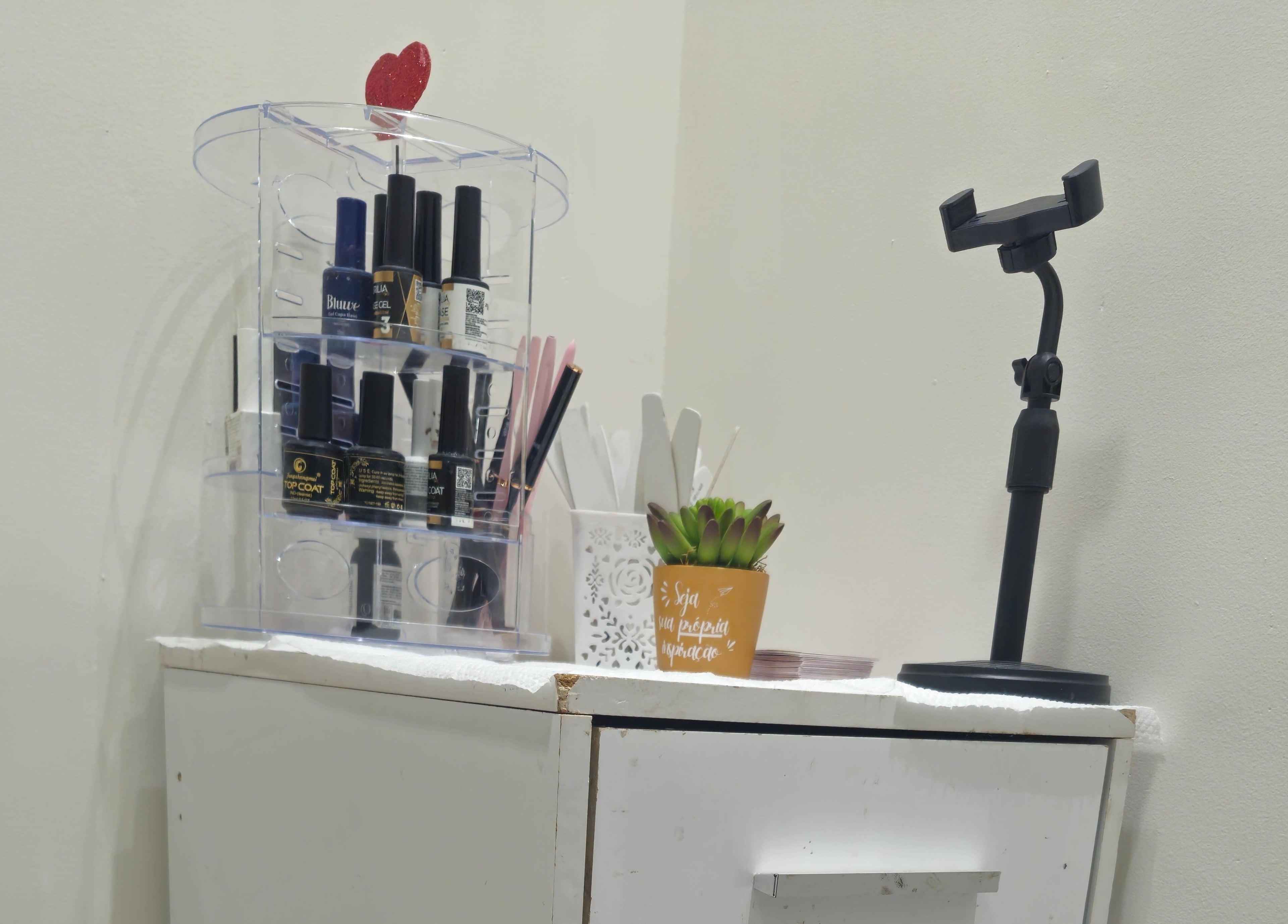 Mesa de manicure organizada no Studio de Unhas, Bauru, São Paulo, BR com esmaltes e decoração.