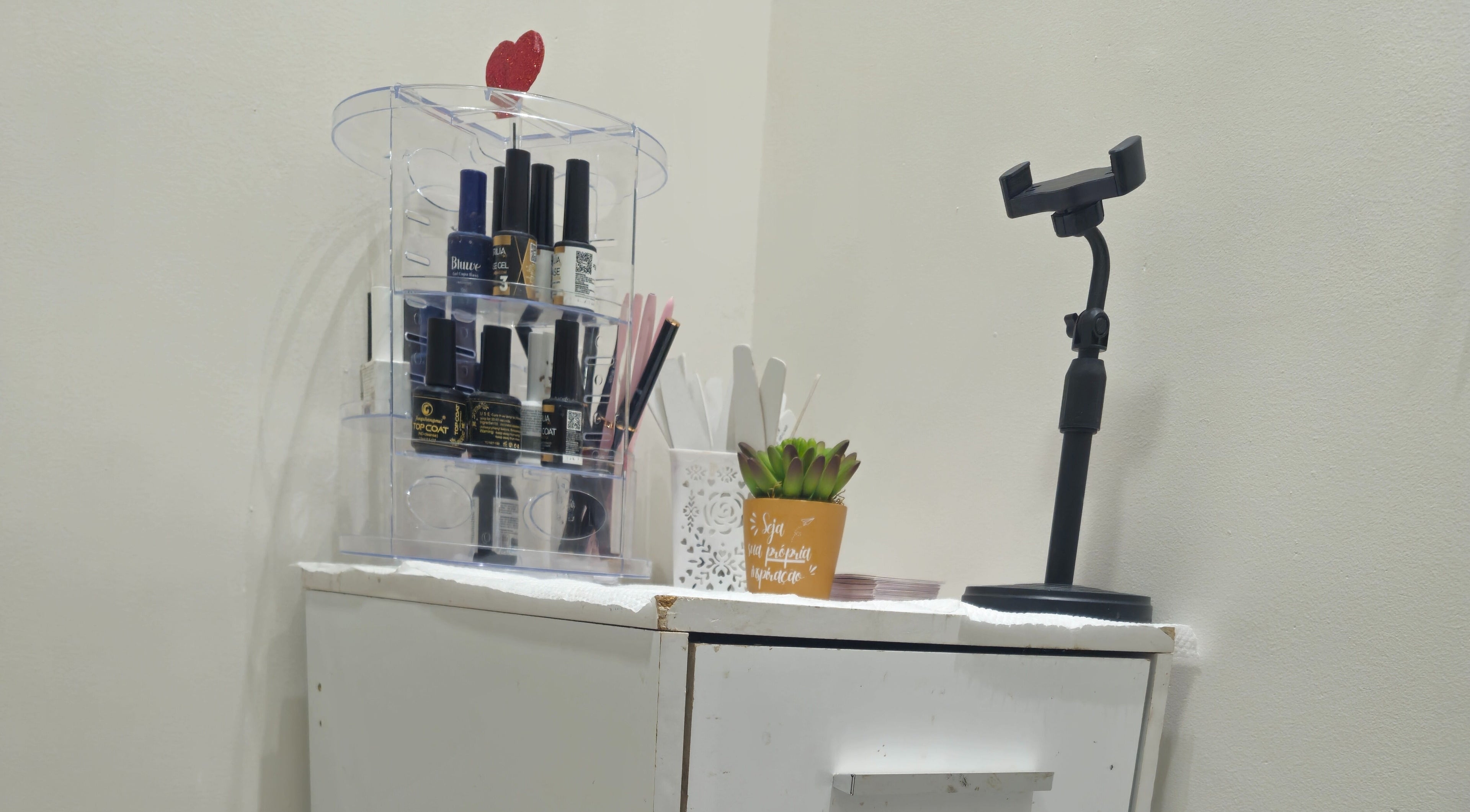 Mesa de manicure organizada no Studio de Unhas, Bauru, São Paulo, BR com esmaltes e decoração.