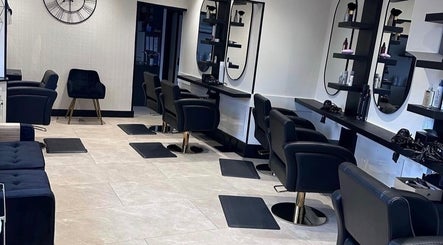 Modern hair salon interior at hairbyelliemay in Royal Tunbridge Wells, England, GB, featuring sleek black chairs.