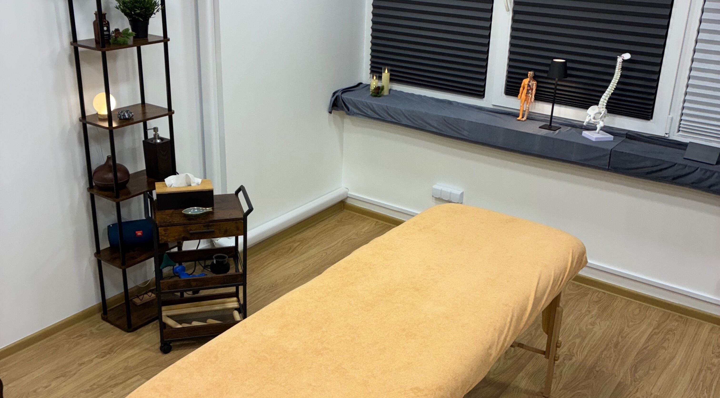 Cozy massage room at DoMasazas, Kaunas, Kauno Apskritis, LT with a wooden shelf and massage bed.