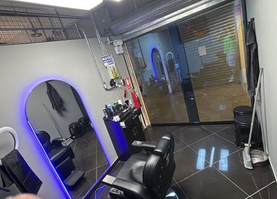 Modern interior of Medina BarberStudio in Bellavista, Callao, PE showcasing a sleek barber chair and mirror.