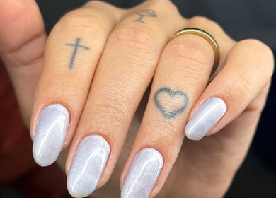 Unhas polidas em Studio Mhabe Nail, Brighton And Hove, England, GB, com tatuagens discretas nos dedos.