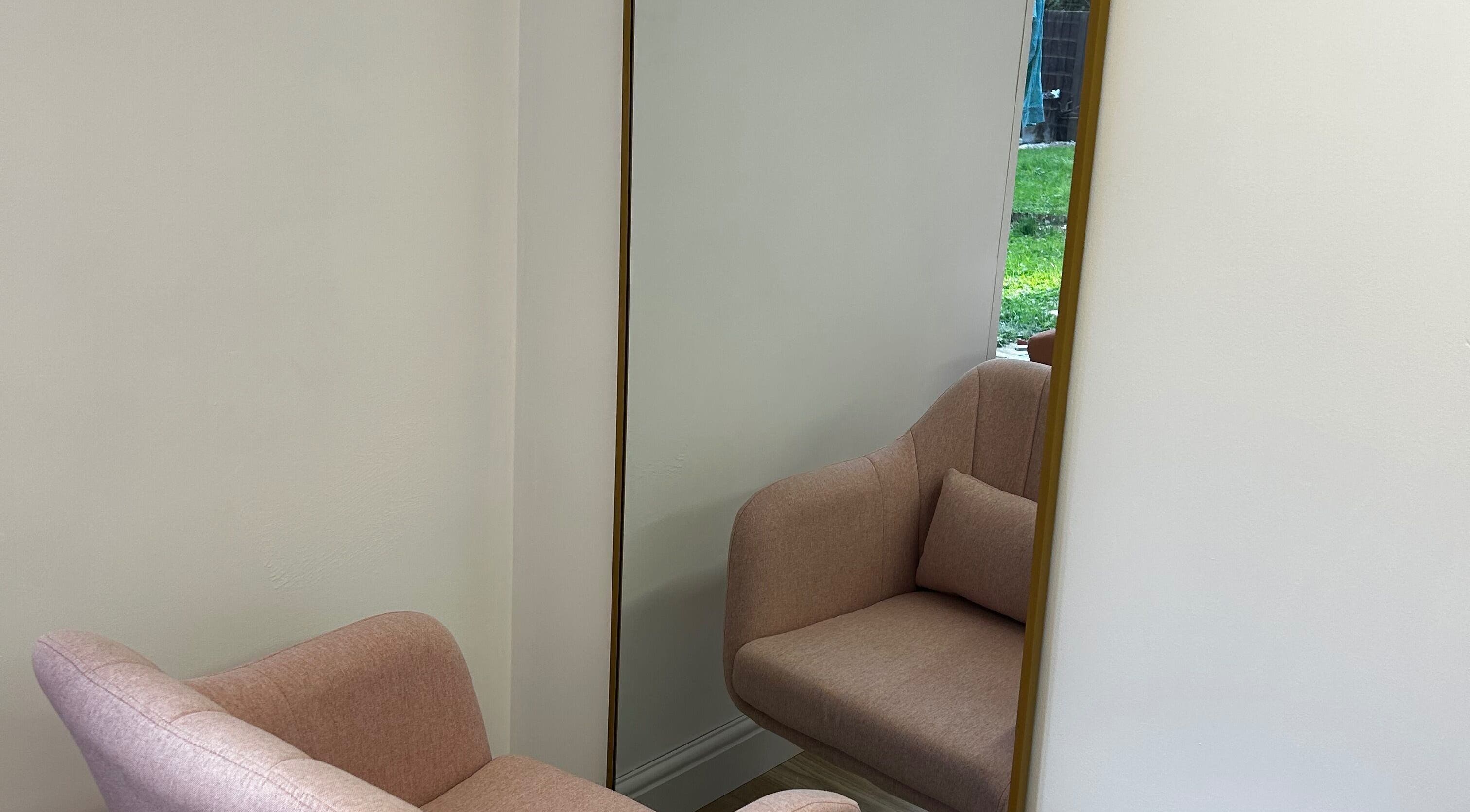 Elegant pink chair with a gold-framed mirror at Lvl by Gem, Bristol, England, GB.