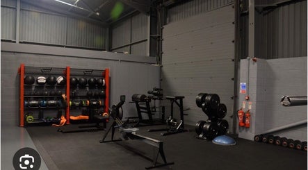 Modern gym at MK Coaching, Halfway, England, GB, showcasing diverse fitness equipment in a sleek setting.