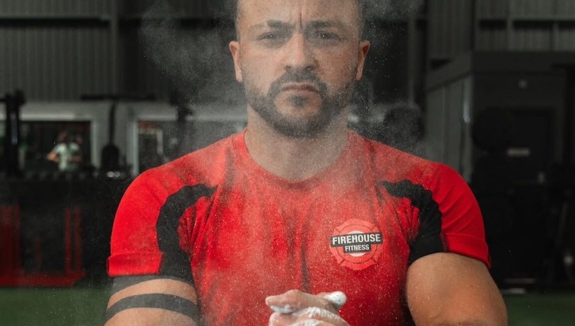 Person in red shirt at MK Coaching gym, Halfway, England, GB, preparing with focus.