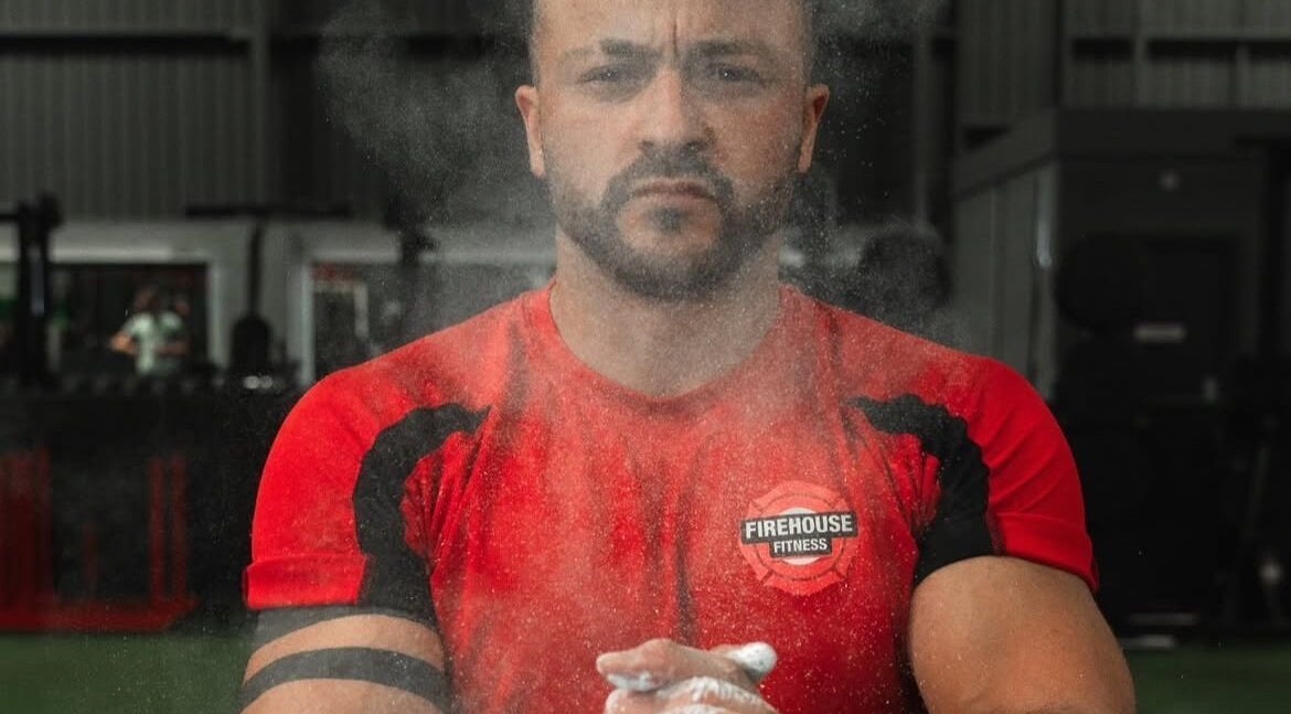 Person in red shirt at MK Coaching gym, Halfway, England, GB, preparing with focus.