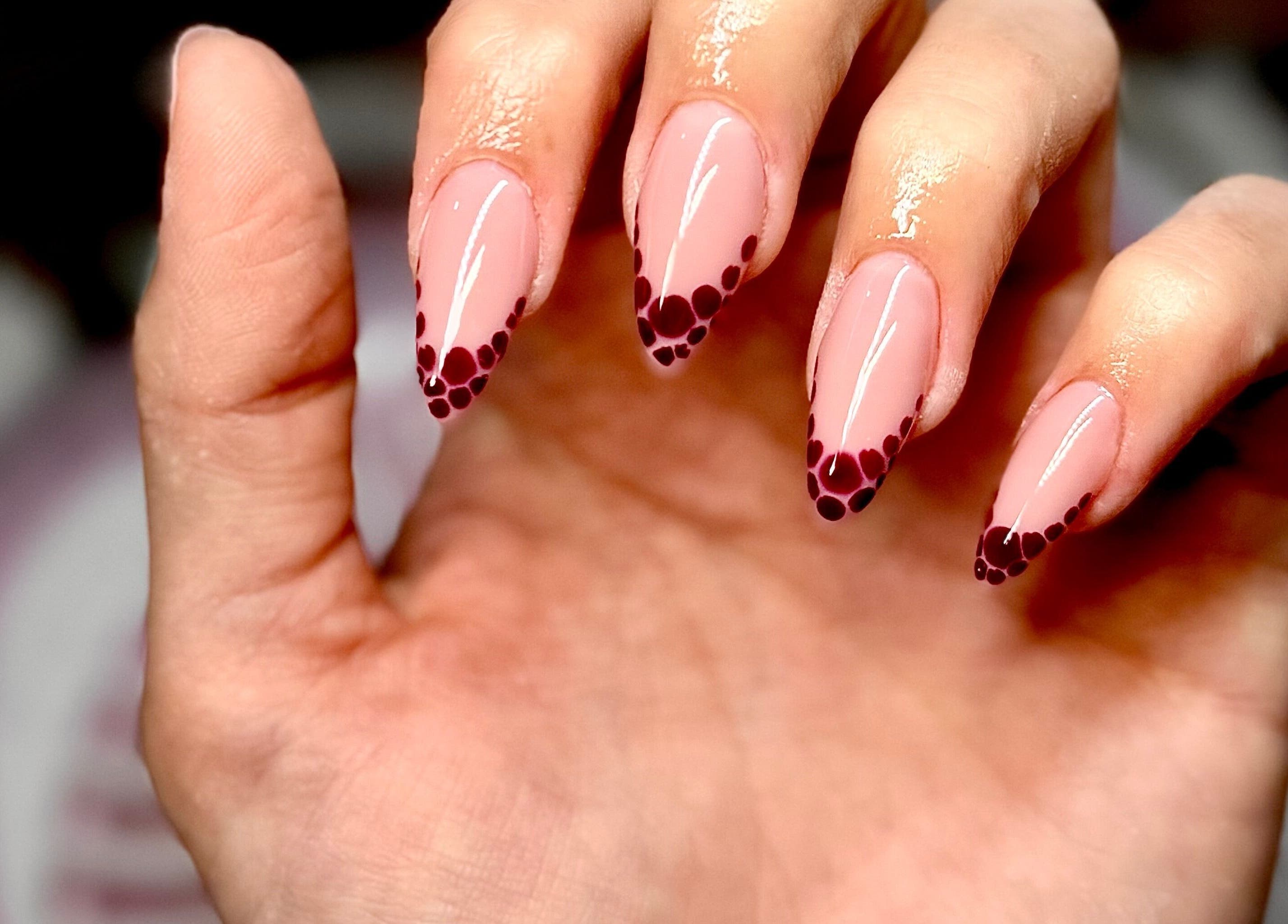 Stylish polka-dotted nail art at Nails by Klaudia, London, England, GB. Perfect for a chic look.