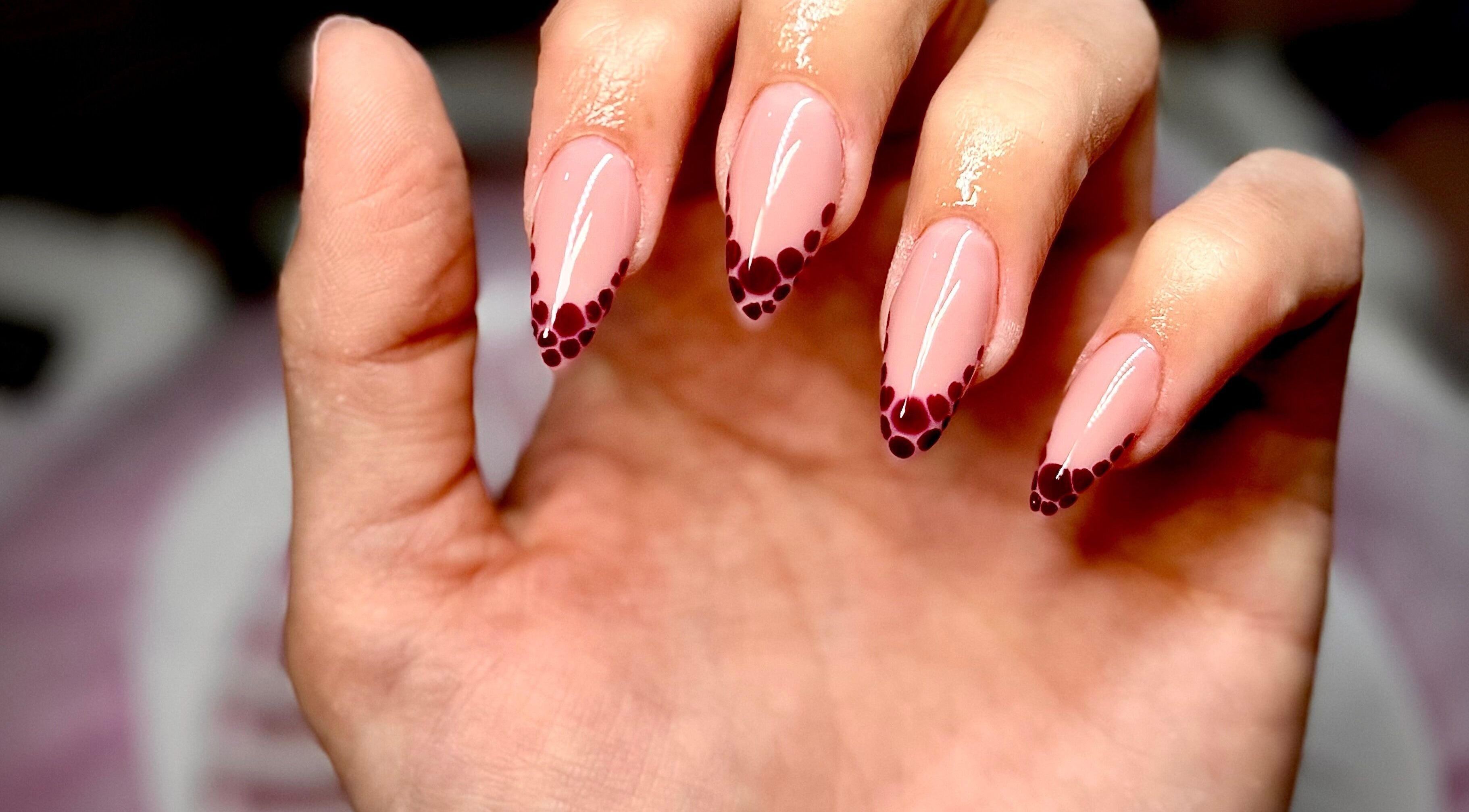 Stylish polka-dotted nail art at Nails by Klaudia, London, England, GB. Perfect for a chic look.