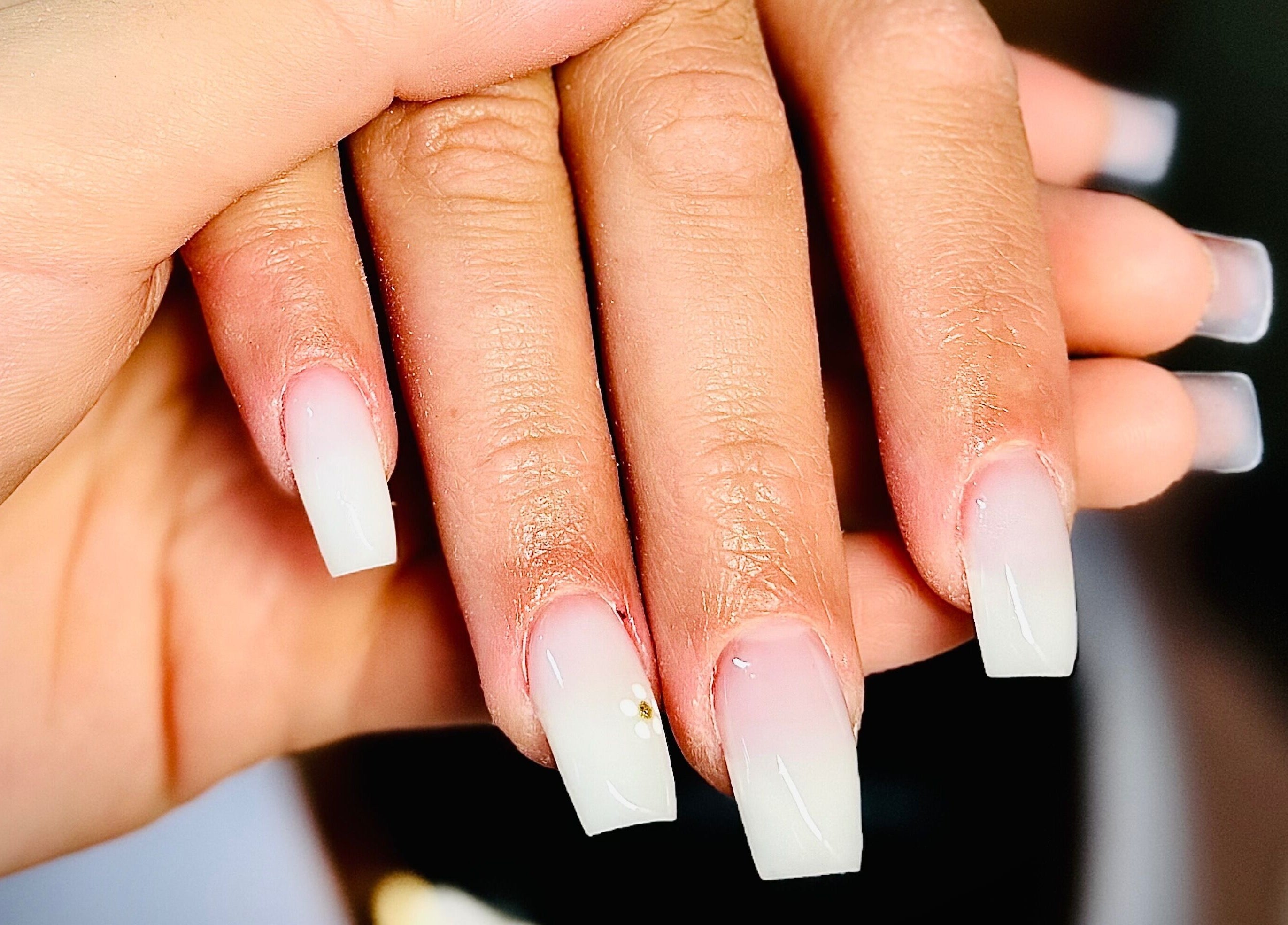 Stylish ombré nails with floral accents at Nails by Klaudia, London, England, GB.