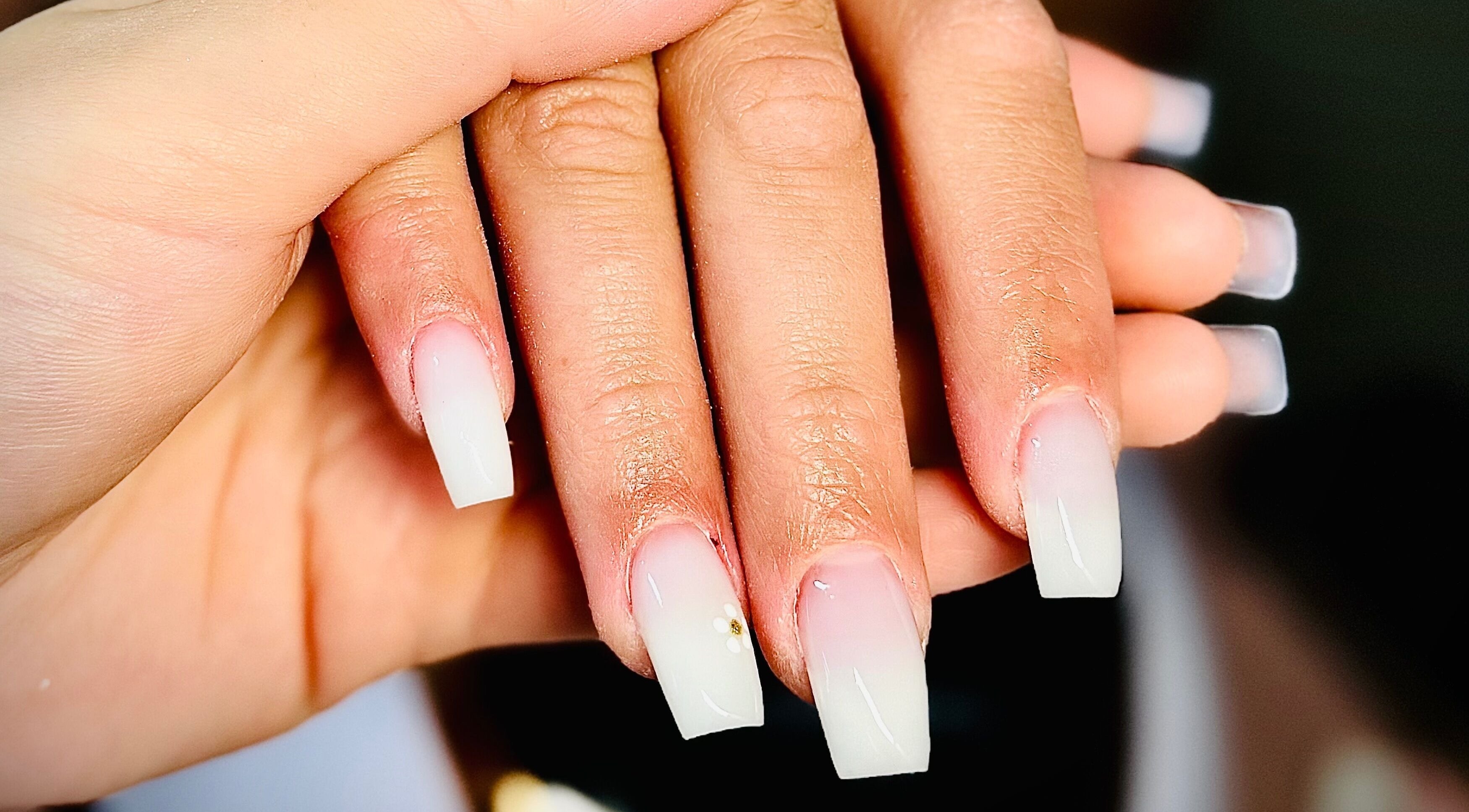 Stylish ombré nails with floral accents at Nails by Klaudia, London, England, GB.