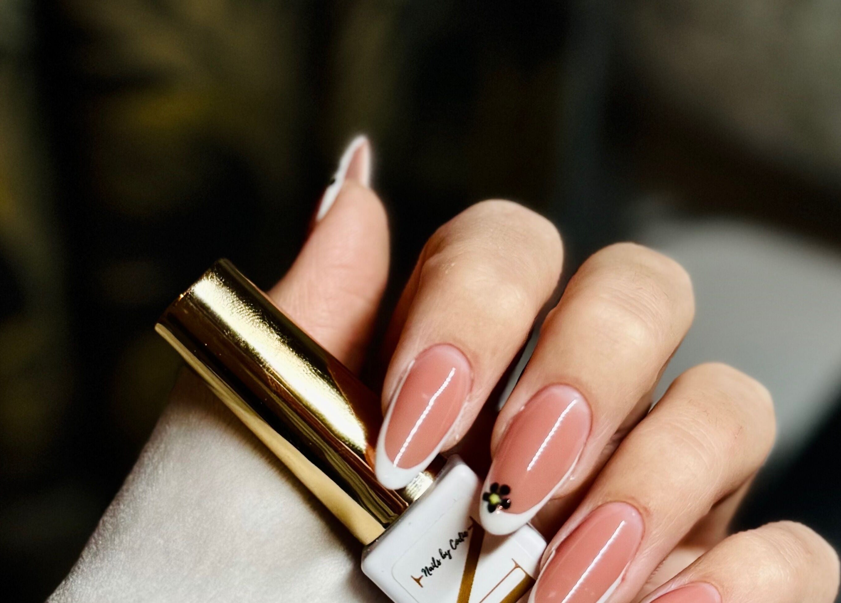 Chic nail design from Nails by Klaudia in London, England, GB featuring a delicate flower accent.