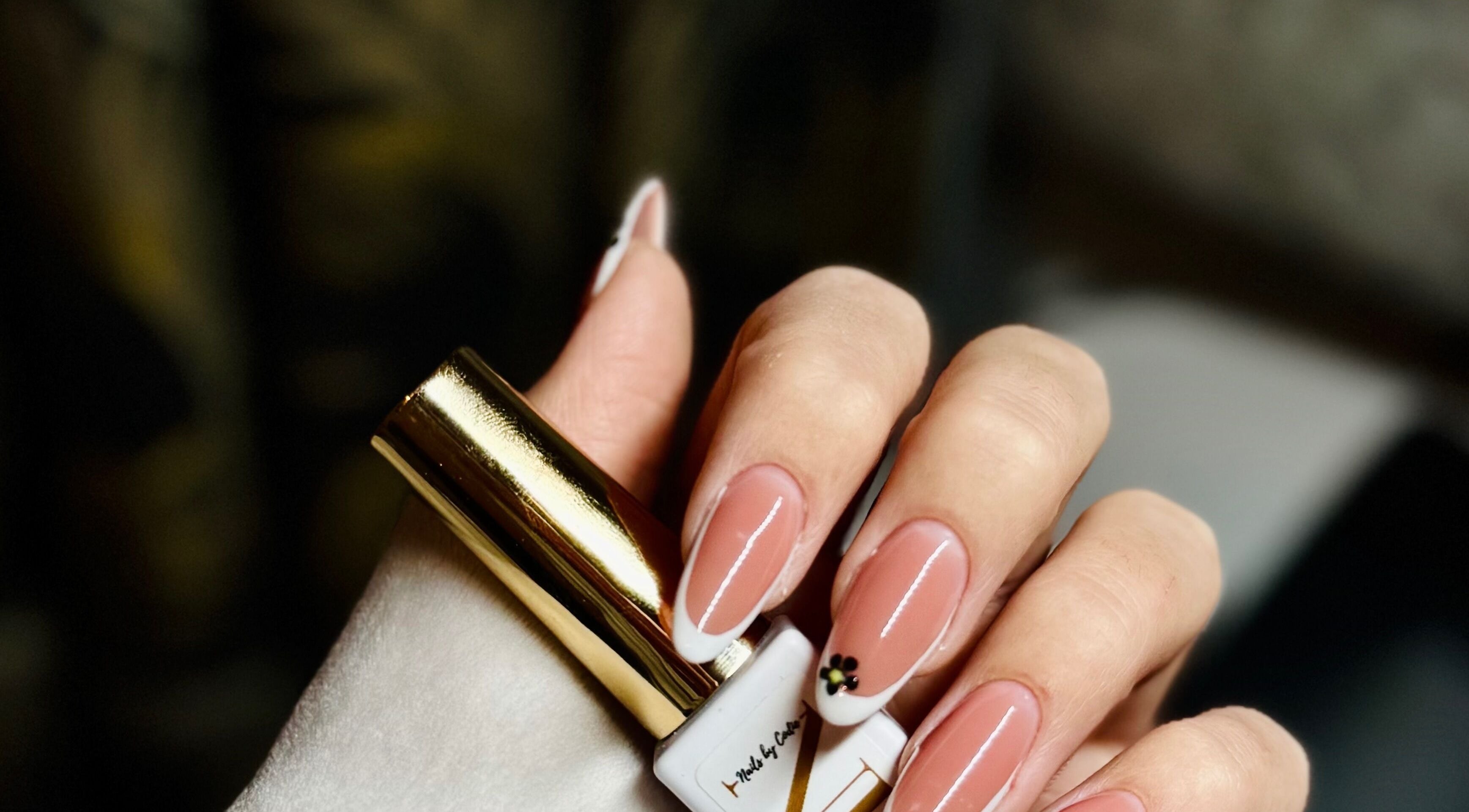 Chic nail design from Nails by Klaudia in London, England, GB featuring a delicate flower accent.