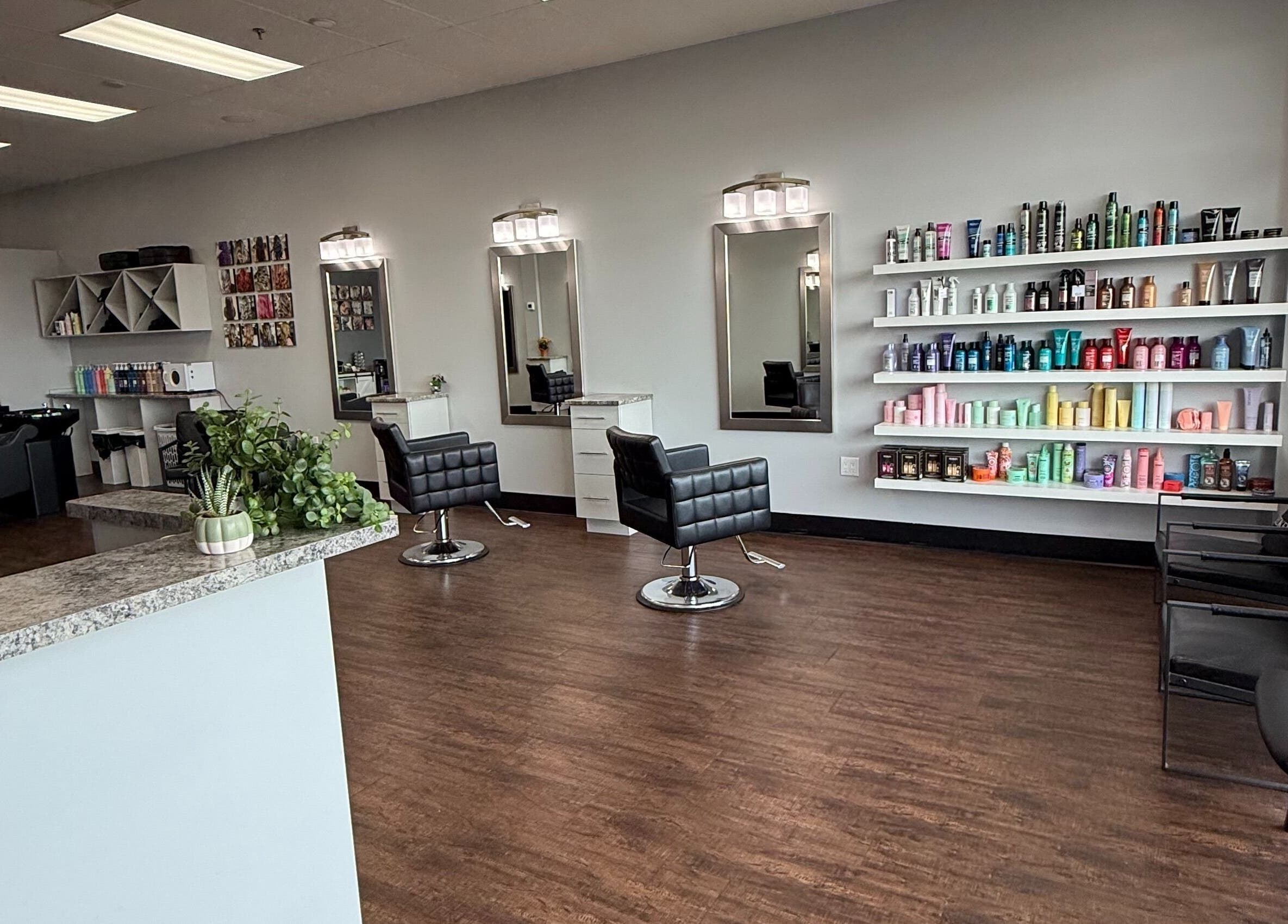 Custom Hair Lounge in Courtenay, BC, CA features modern styling chairs and a vibrant product display wall.