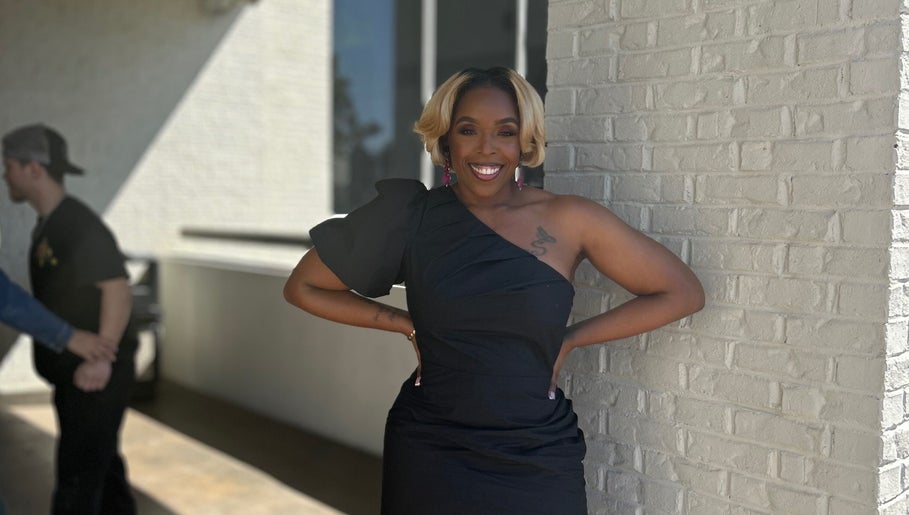 A person in elegant attire outside Pamper You Studio, Hueytown, Alabama, US, exudes confidence.