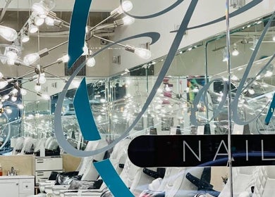 Modern interior of Polished Nail Bar DTLA, Los Angeles, California, US with mirrored walls and stylish lighting.