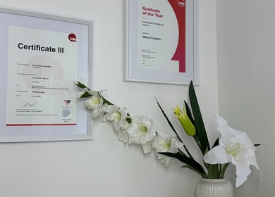 Framed certificates and elegant flowers at Alter Beauty, Harristown, Queensland, AU.
