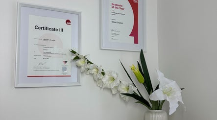 Framed certificates and elegant flowers at Alter Beauty, Harristown, Queensland, AU.