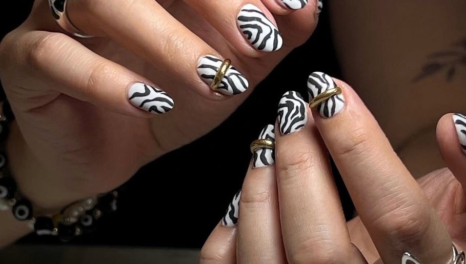 Stylish zebra print nails with gold accents at MAKOKI NAILS, Zapopan, Jalisco, MX.