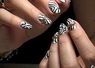 Stylish zebra print nails with gold accents at MAKOKI NAILS, Zapopan, Jalisco, MX.