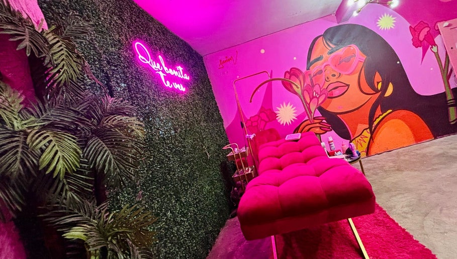 Sala de belleza MOONLASH en San Luis Potosí, MX con mural vibrante y sofá rosa.