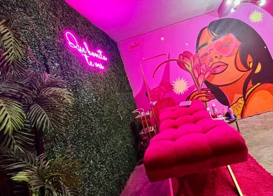 Sala de belleza MOONLASH en San Luis Potosí, MX con mural vibrante y sofá rosa.