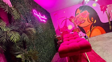 Sala de belleza MOONLASH en San Luis Potosí, MX con mural vibrante y sofá rosa.