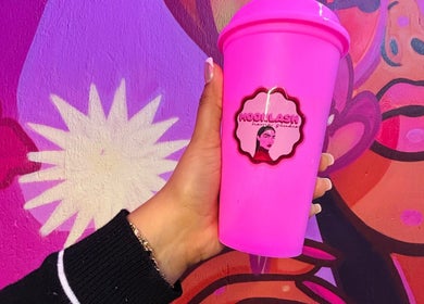 Taza rosa con logotipo de MOONLASH frente a mural colorido en San Luis Potosí, MX.