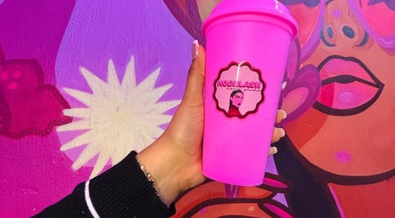 Taza rosa con logotipo de MOONLASH frente a mural colorido en San Luis Potosí, MX.