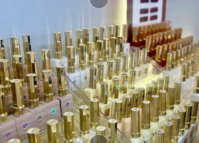 Bộ sưu tập sơn móng tay tại Unique Nails München, München, Bayern, DE, với chai thiết kế màu vàng sang trọng.