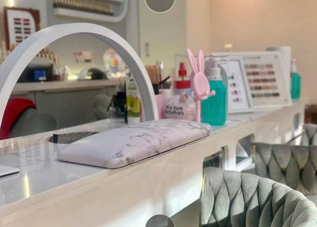 Bàn làm móng hiện đại tại Unique Nails München, München, Bayern, DE với ghế xám lịch sự.