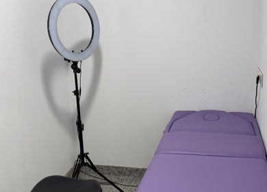Sala de tratamiento en Juliet Piercer & Tattoo, Málaga, Andalucía, ES, con camilla y luz de anillo.
