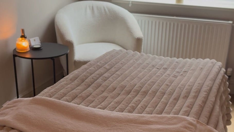 Relaxing spa room at Positive Skincare in Monton, England. Features plush chair and warm lighting.