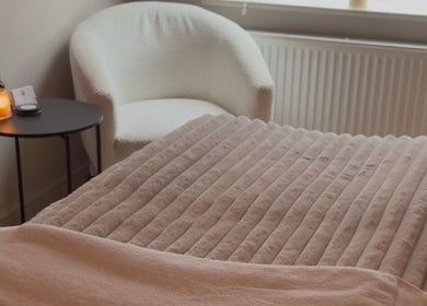 Relaxing spa room at Positive Skincare in Monton, England. Features plush chair and warm lighting.