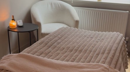 Relaxing spa room at Positive Skincare in Monton, England. Features plush chair and warm lighting.