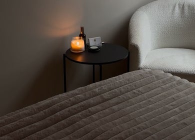 Relaxing treatment room at Positive Skincare in Monton, England, GB with candlelit ambiance and plush seating.