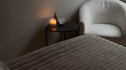 Relaxing treatment room at Positive Skincare in Monton, England, GB with candlelit ambiance and plush seating.