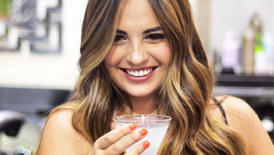 A smiling woman with wavy hair at Blond Plus Felix in Hong Kong Island, Hong Kong Island, HK.
