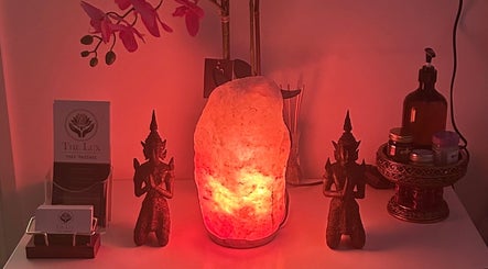 Serene setup at The Lux Thai Massage in Norwich, England, GB with salt lamp, statue, and orchids.