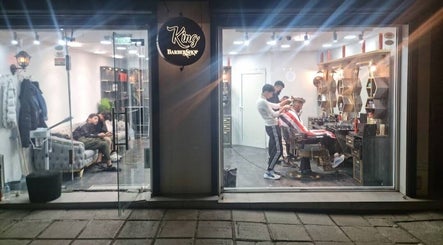 حلاق يعمل على قص شعر زبون في King BarBer Shop في صوفيا، صوفيا سيتي، BG.