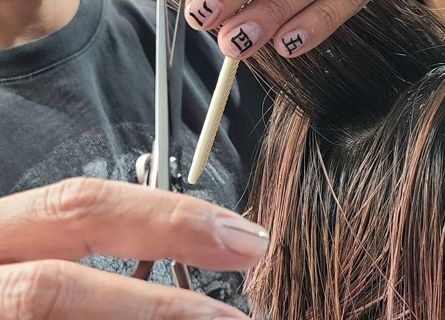 Close-up of hairstylist cutting hair at Artworks96s | At Quark Hair Studio, London, England, GB.