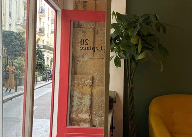 Vue intérieure de Bj Studio à Paris, Île-de-France, FR, avec porte rouge et canapé jaune.