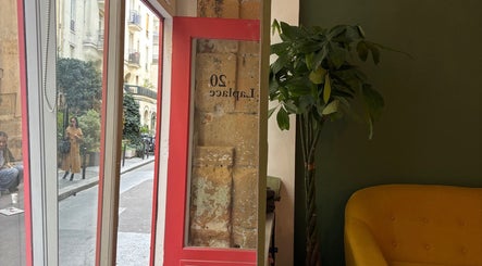Intérieur élégant de Bj Studio à Paris avec une porte rouge et un canapé jaune, Île-de-France, FR.