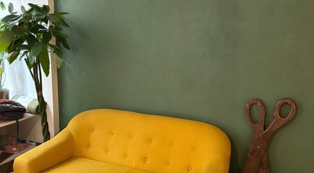 Salon lumineux avec canapé jaune à Bj Studio, Paris, Île-de-France, FR, décoré d'une plante verte.