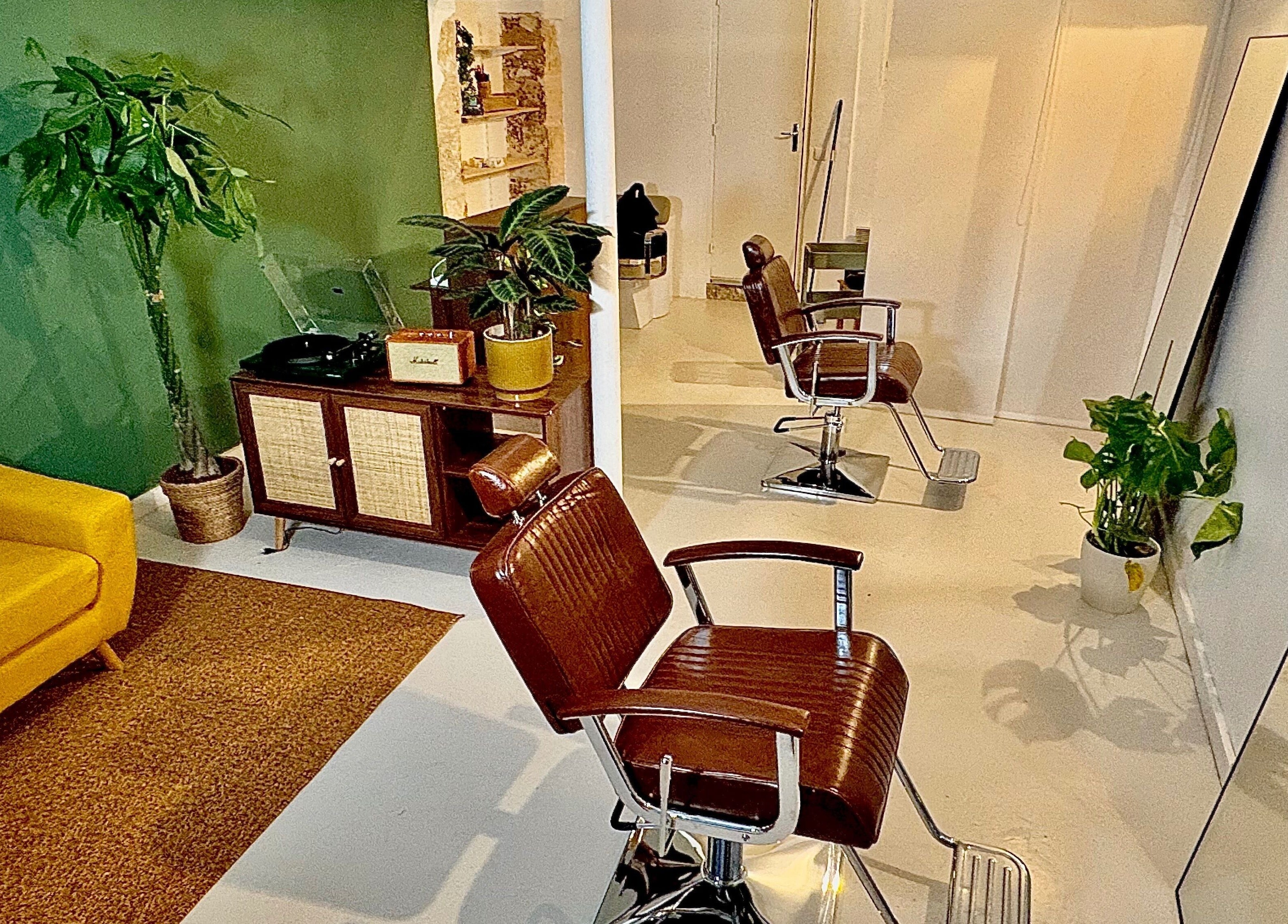 Intérieur chic de Bj Studio à Paris, Île-de-France, FR avec canapé jaune et fauteuils de coiffure.